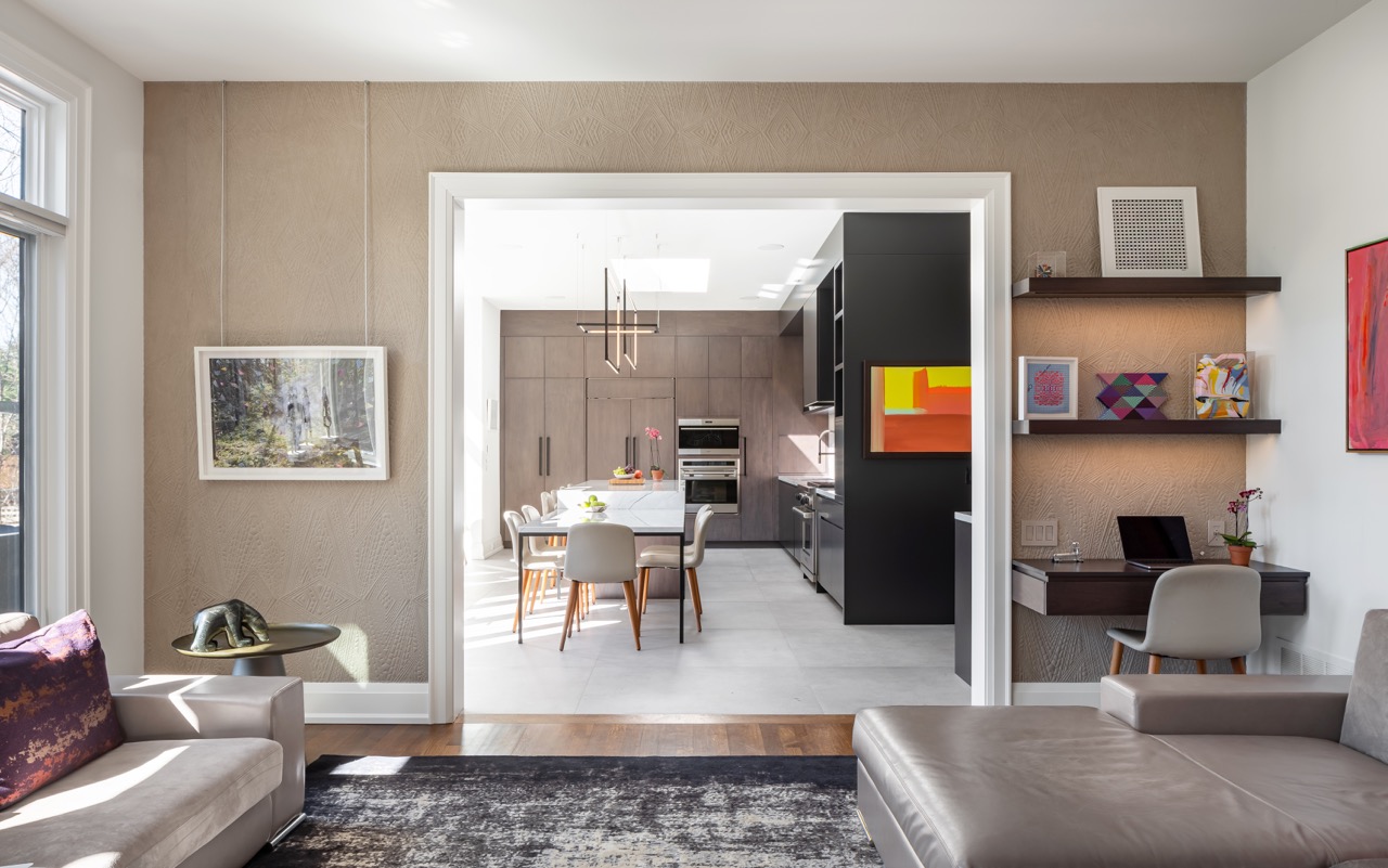 Stylish South Hill: This South Hill renovation is anchored by a dramatic kitchen that doubles as the dining room: a single waterfall marble island runs the length of the space, seating both stools and a full dining table beneath a run of skylights…