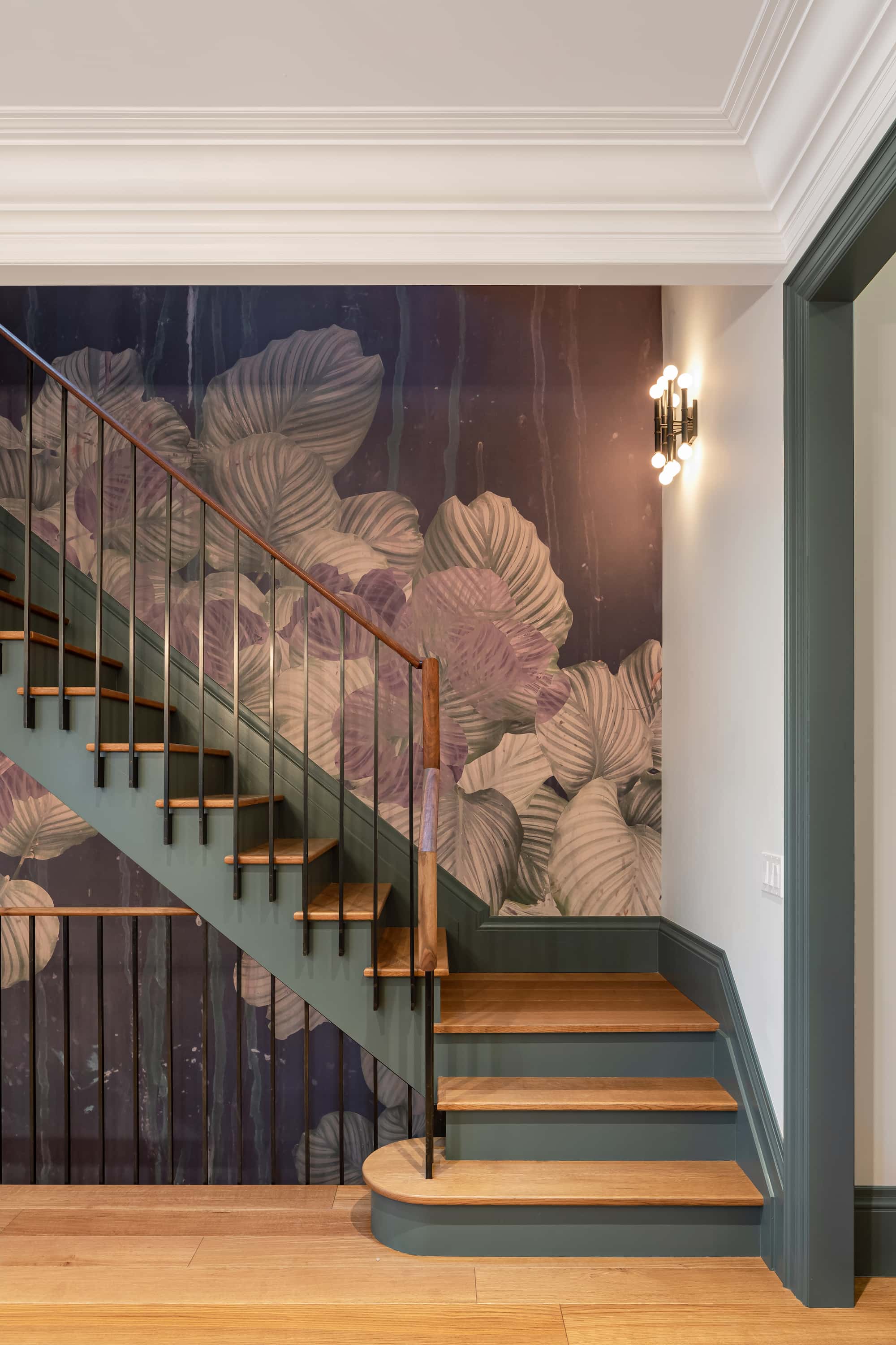 Astounding Annex: A hand-painted floral mural lines the stairwell in a rich rust and blush palette, and deep green door trim and crown moulding carry a sense of old-world detail through the rest of the main floor