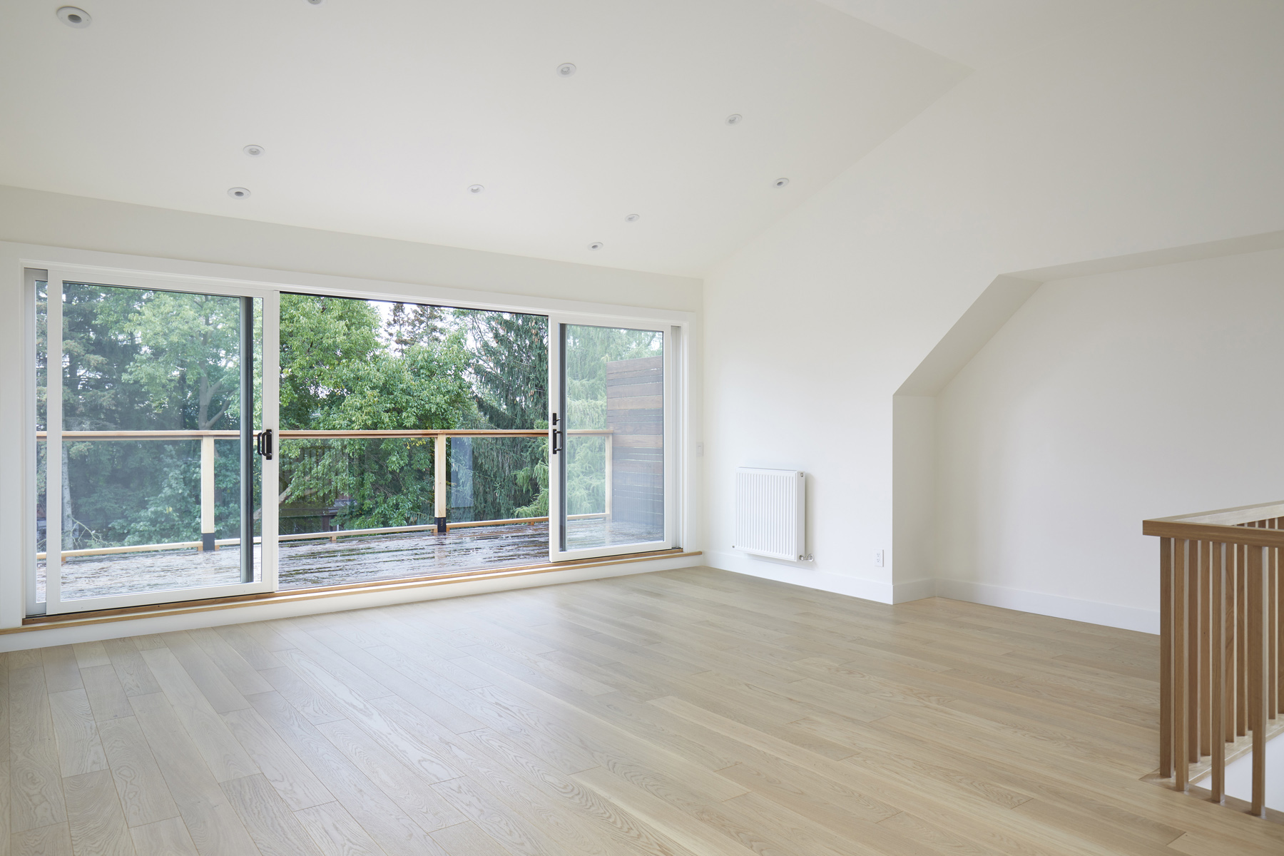 Roncesvalles Remodel: Custom fir windows and an oversized lift and slide glass door were used across the back of the house to bring in the light, call attention to the lush surroundings and provide access to the massive deck clad in thermally…
