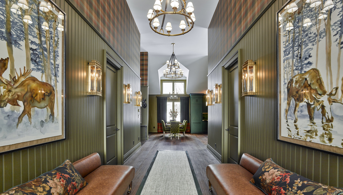 Country Retreat: The wall treatment continues through the main floor to the living room, highlighted by a large and inviting limestone fireplace that gives the relaxed room a note of grandeur
