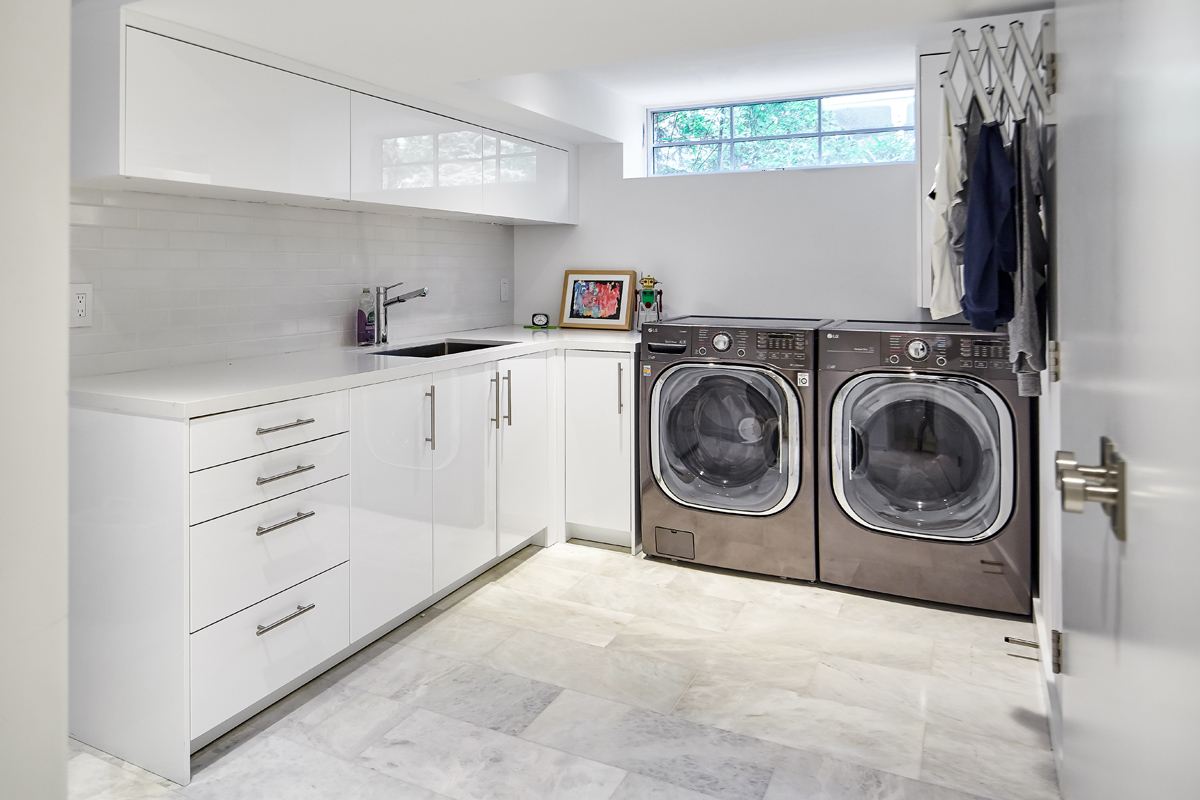 Beautiful Baby Point: The kitchen's crisp, clean palette is the perfect neutral foil for the handmade backsplash, and generous floor-to-ceiling windows provide a vista to the lush green yard and onto the Humber ravine