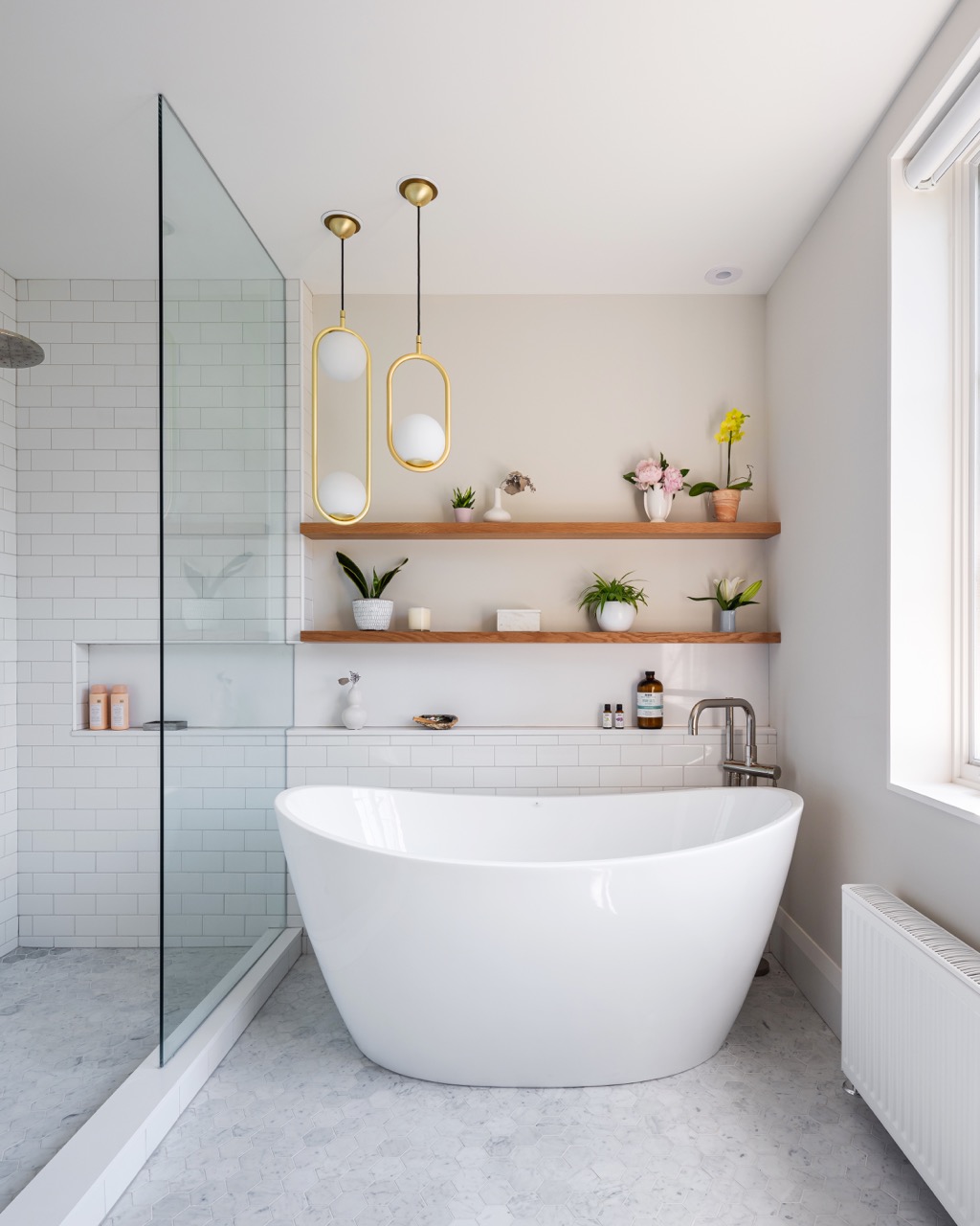 Rusholme Restored: Upstairs, statement botanical wallpaper anchors two bathrooms finished with white oak vanities, farmhouse sinks, and brass fixtures, while a third bath keeps things bright with subway tile, a freestanding oval tub, and floating…
