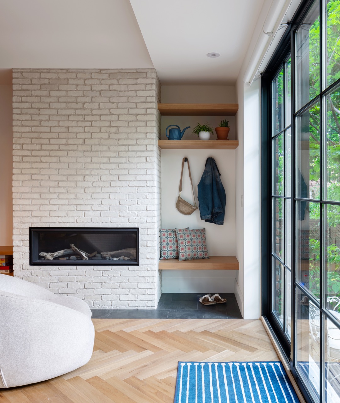 Rusholme Restored: This Rusholme home was reworked around one big, light-filled great room, where a whitewashed brick fireplace and full-height oak built-ins frame a media wall, and steel-framed glass doors fold open to the backyard
