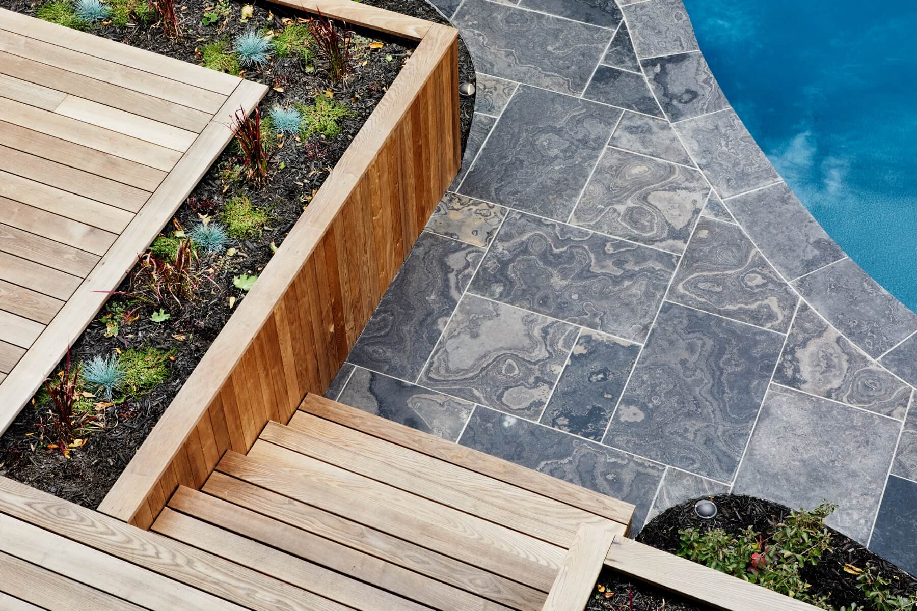 Islington Village: This project included a full reimagining of the backyard landscaping and features the use of Thermory decking and a refurbished in-ground pool surrounded by dark Eramosa limestone