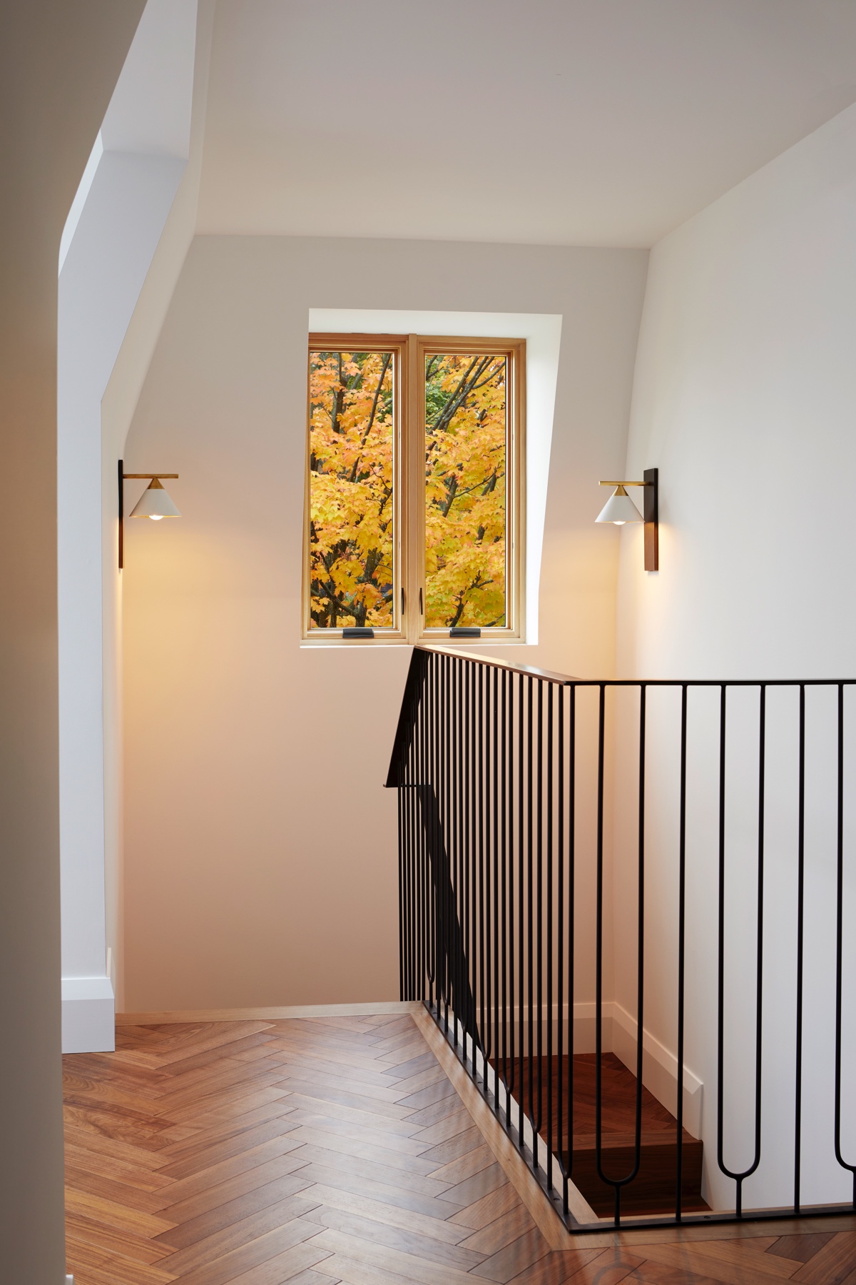 Islington Village: The main walnut waterfall staircase features a custom hand forged metal railing with tuning fork spindles