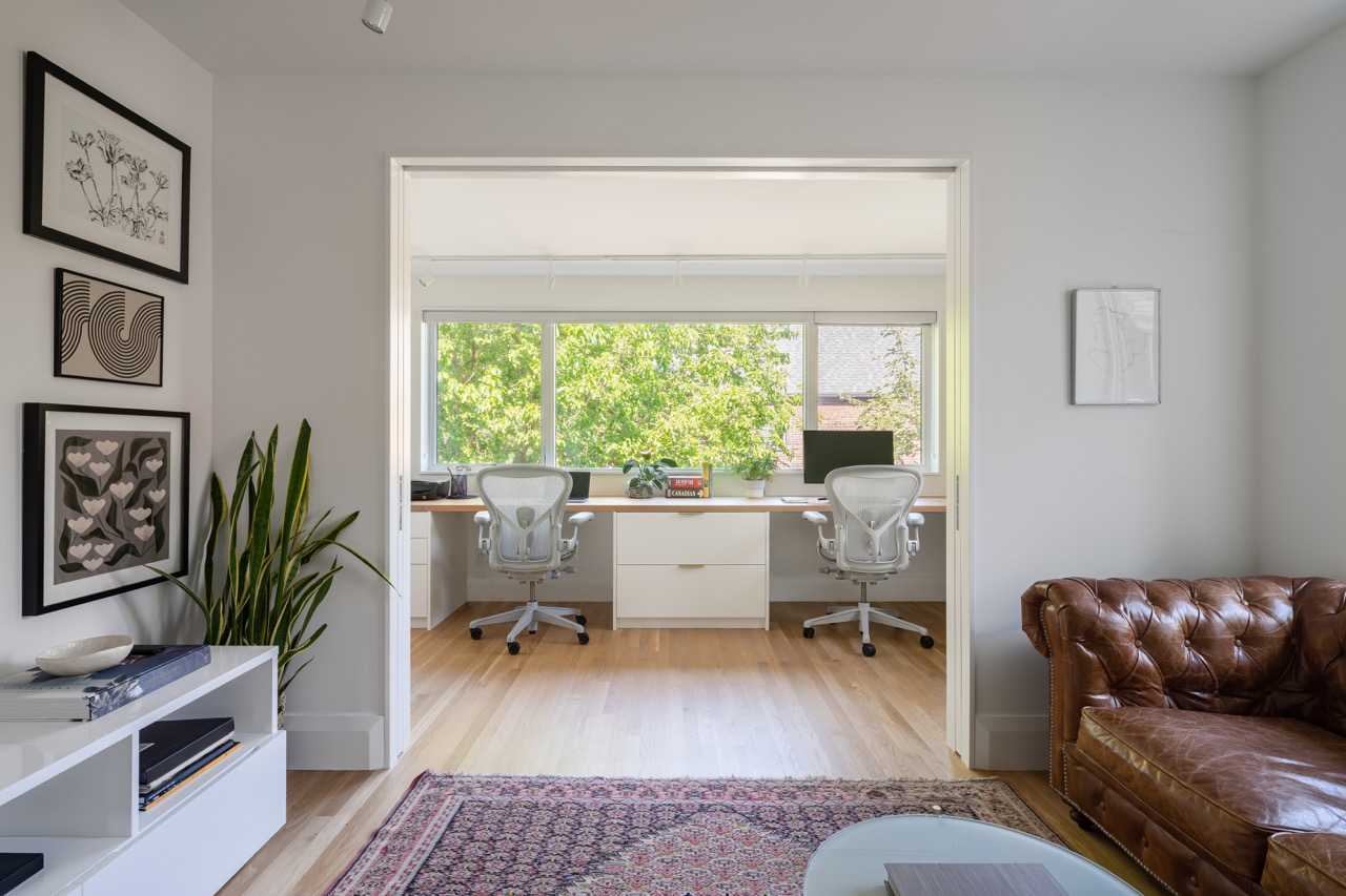 Picturesque Parkside: The exterior kept its dark gabled roofline, wraparound porch, and brick facade intact, while the interior was reimagined around a moody charcoal kitchen with a white oak island, subway tile hood surround, and full-height…