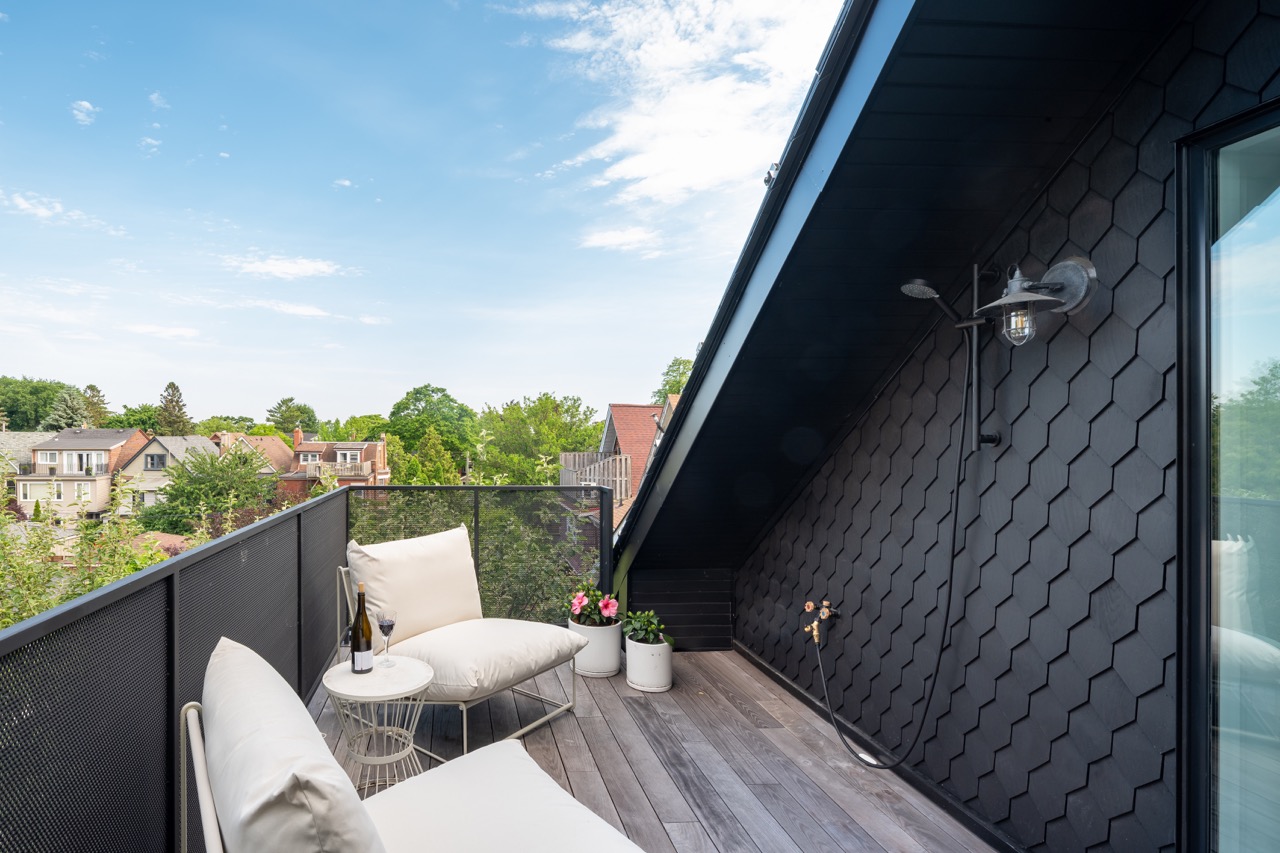 Picturesque Parkside: The exterior kept its dark gabled roofline, wraparound porch, and brick facade intact, while the interior was reimagined around a moody charcoal kitchen with a white oak island, subway tile hood surround, and full-height…