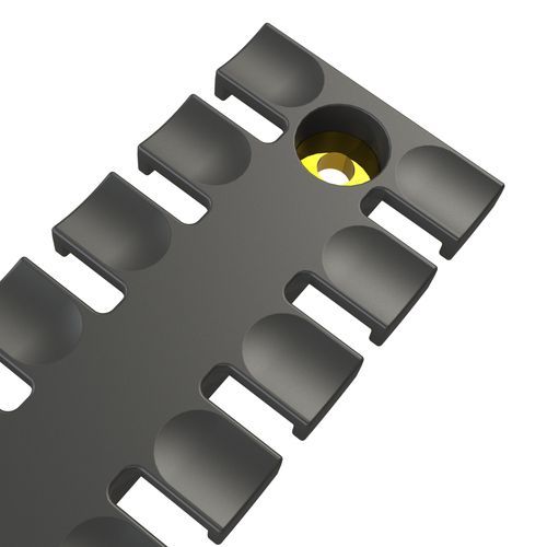 Dark grey cable entry with a gold-coloured ring in the centre and several slots on the sides