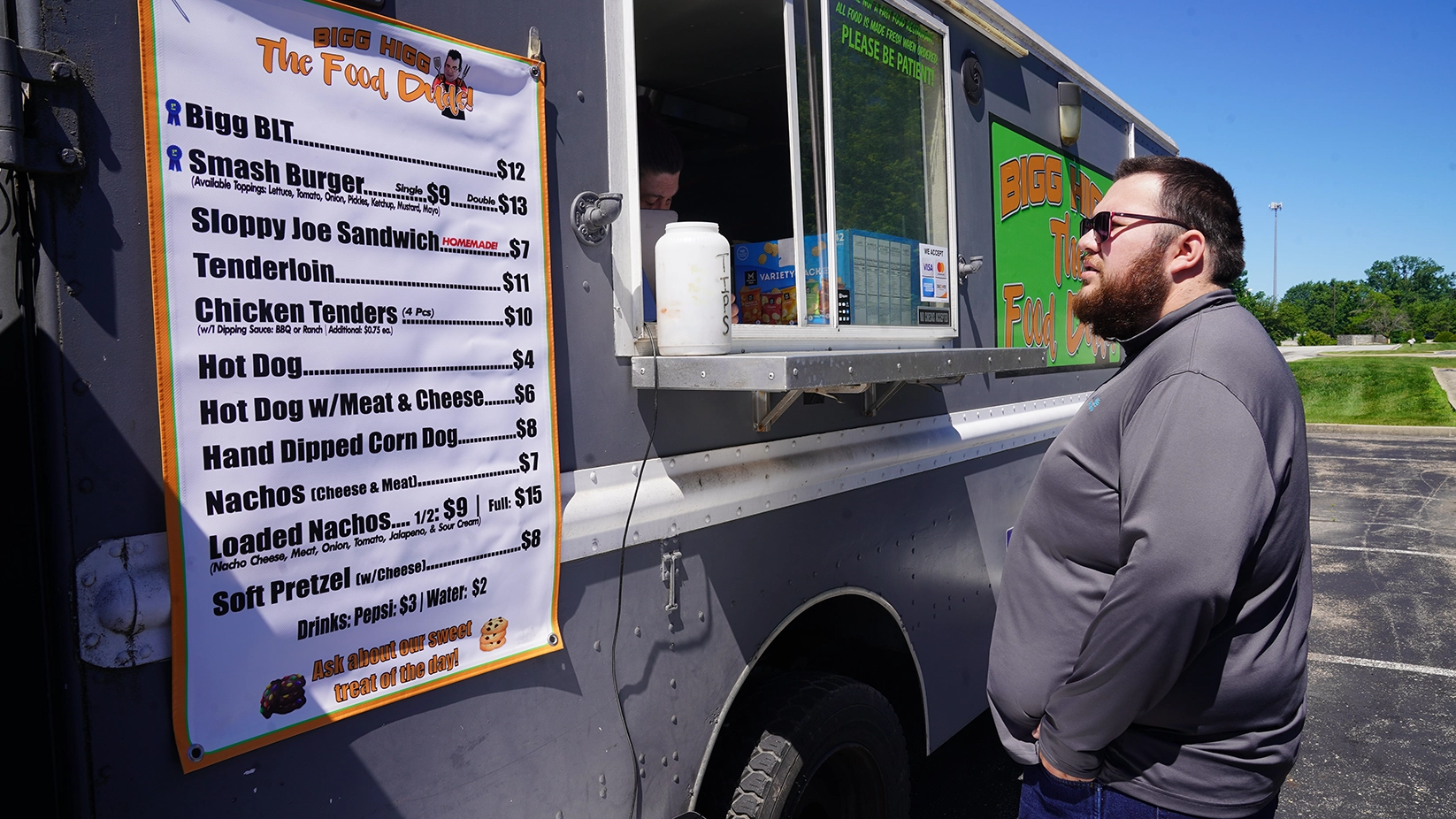 A young man looks at the menu displayed on a food truck at Flagship Enterprise Center.