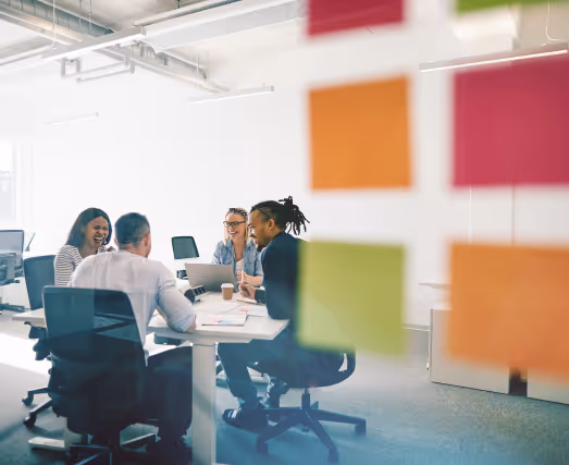 People working in an office setting with post its on a glass wall