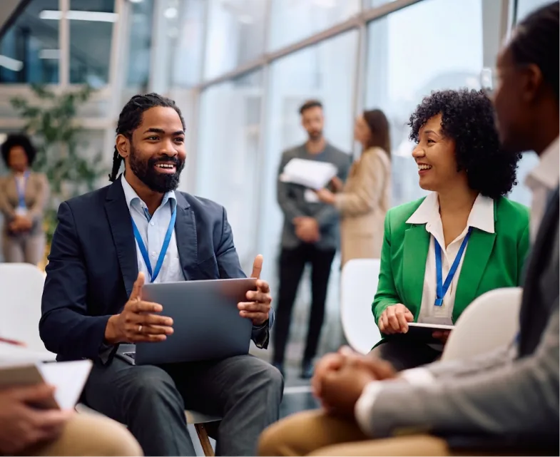 People networking at a conference with event badges and laptops