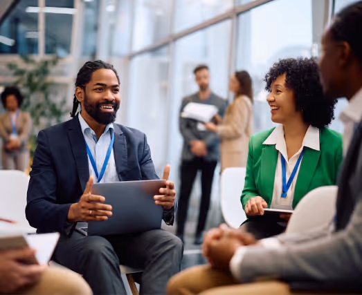 People networking at a conference with event badges and laptops