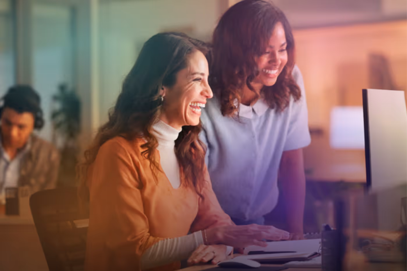 Marketing professionals smiling and working together on a computer