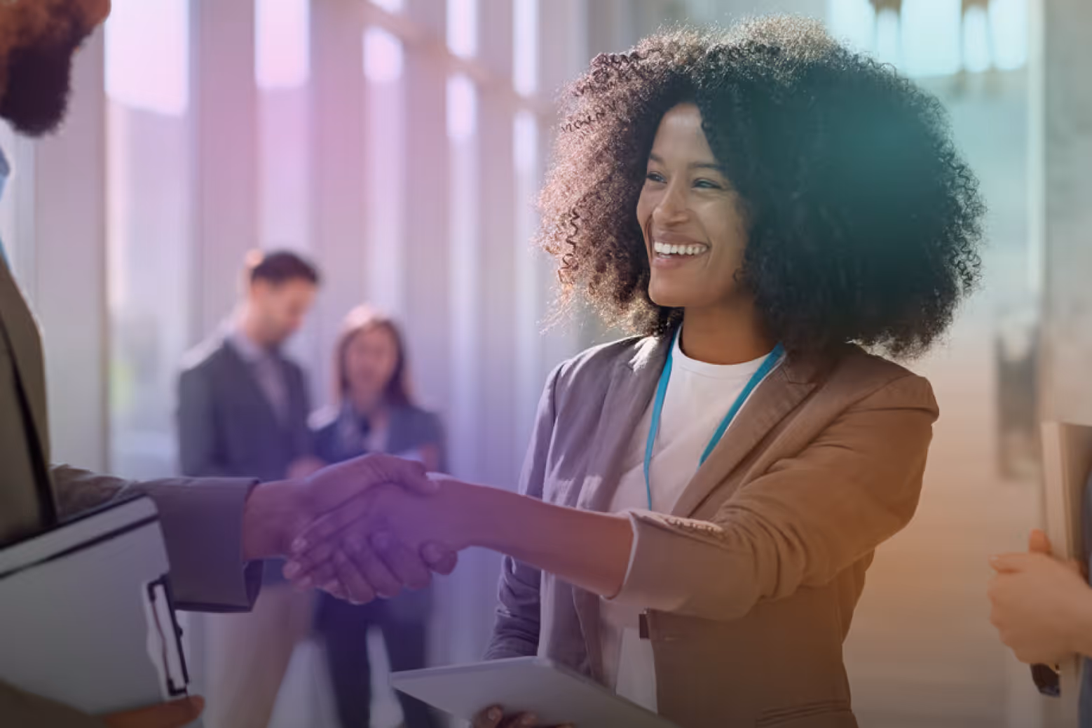 Sales professionals shaking hands at a conference.