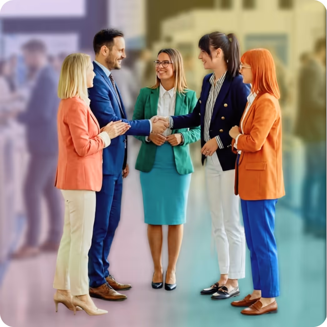 Business professionals shaking hands and smiling while greeting one another.