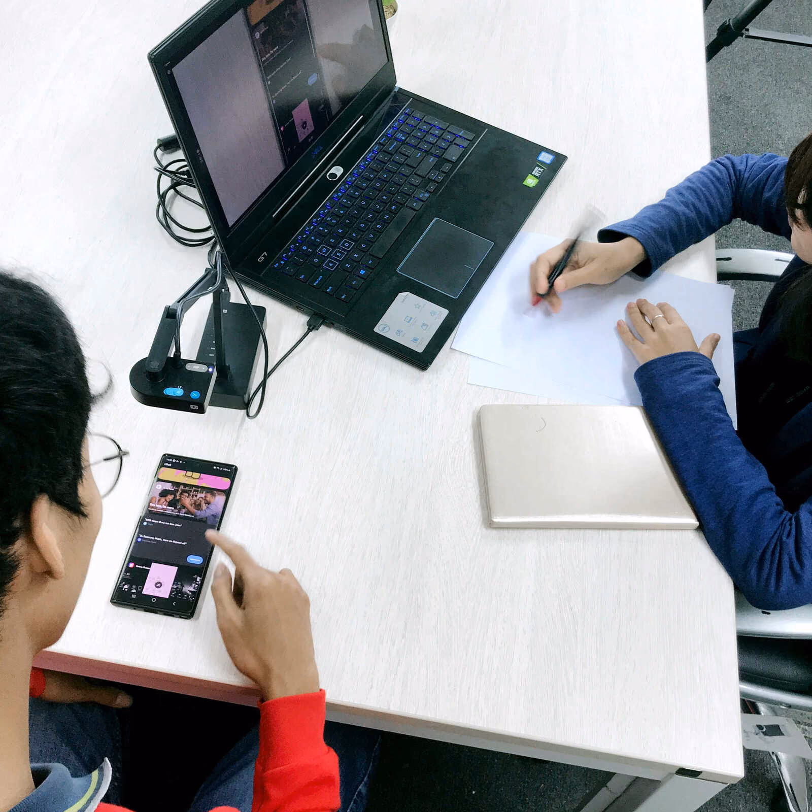 User testing session for a mobile phone prototype while the interviewer tracks the user behaviours on her laptop. 
在手機原型的使用者測試中，訪問者在她的筆記型電腦上跟蹤使用者的行為。