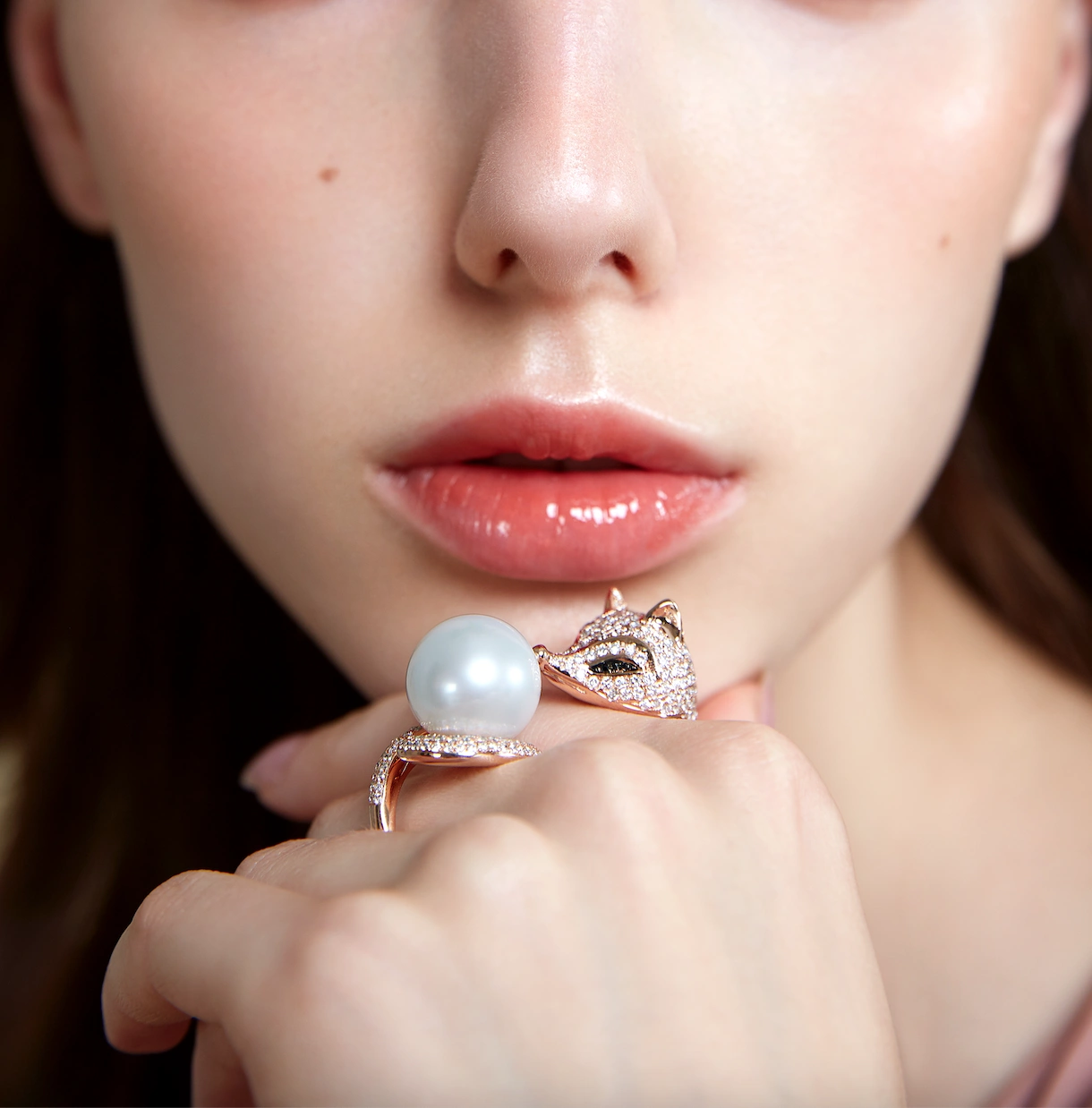 High-end commercial editorial photography showcasing Golston Jewelry's signature diamond-encrusted rose gold fox ring holding a large white South Sea pearl.