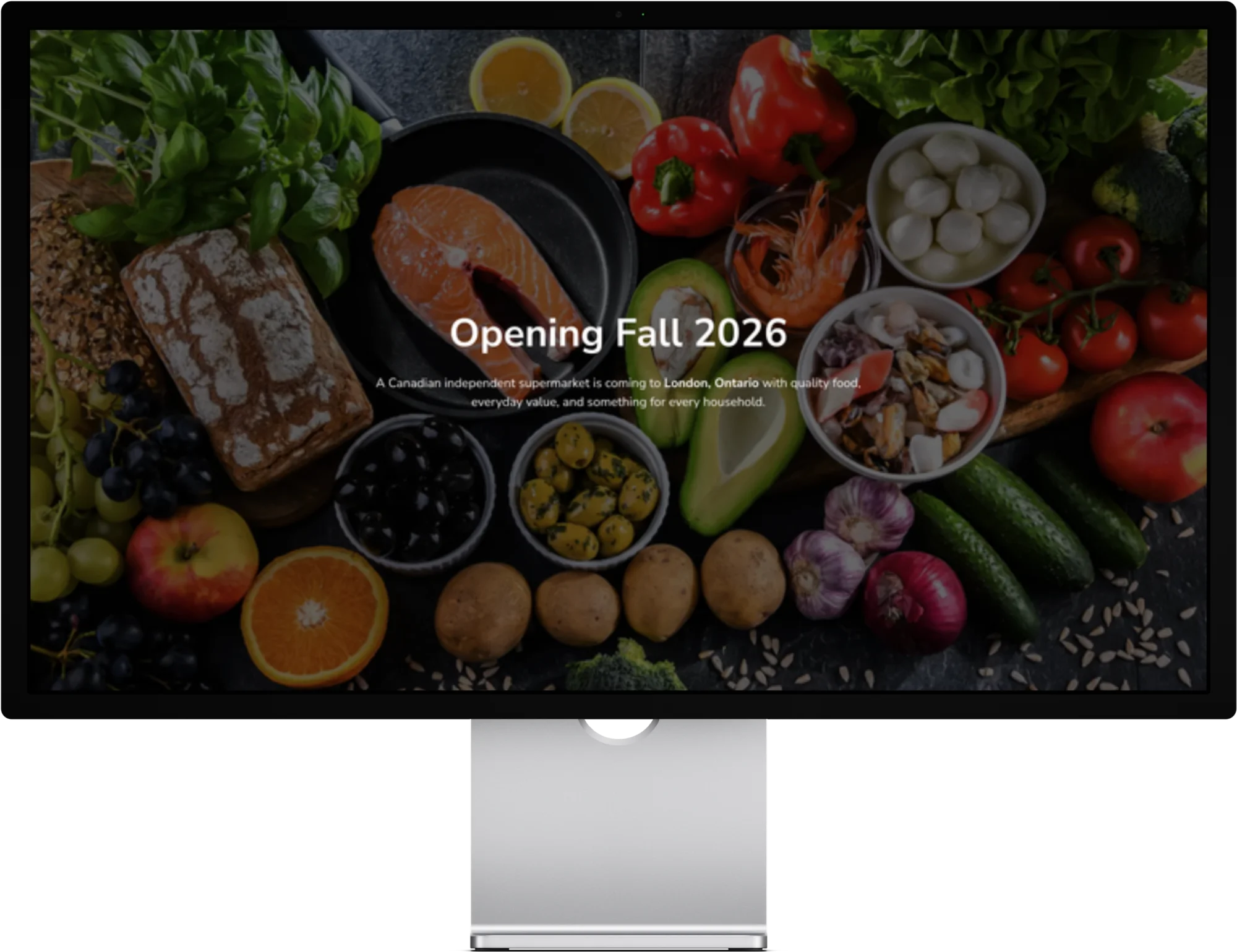 JH Supermarket's coming soon page over a spread of fresh produce, bread, olives and shrimp: "Opening Fall 2026".