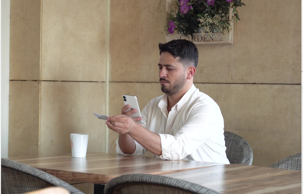 Kafede telefonuyla kimlik kartını tarayan bir müşteri