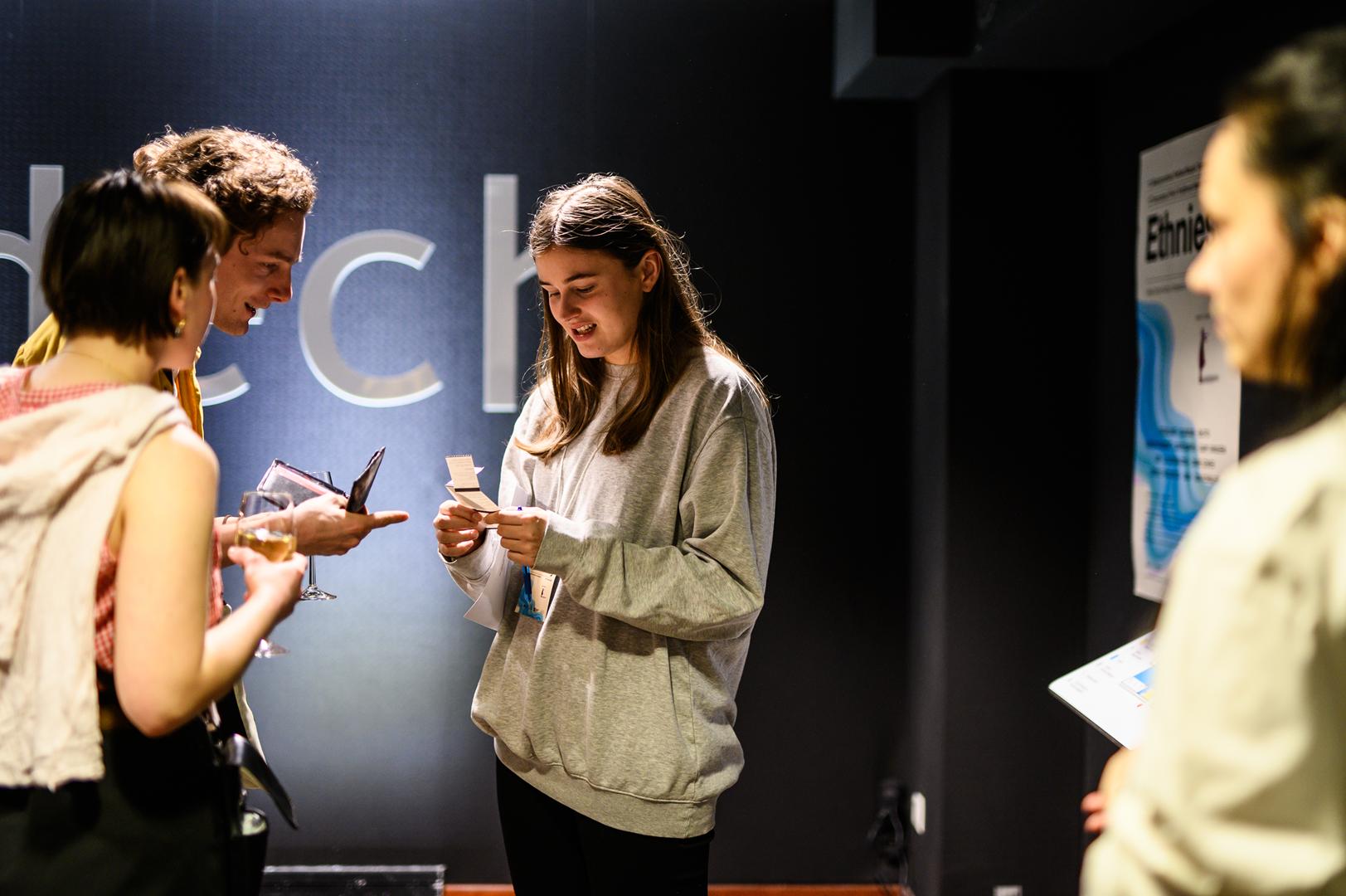 Na zdjęciu widać dziewczynę sprawdzającą bilety dwóm innym osobom.