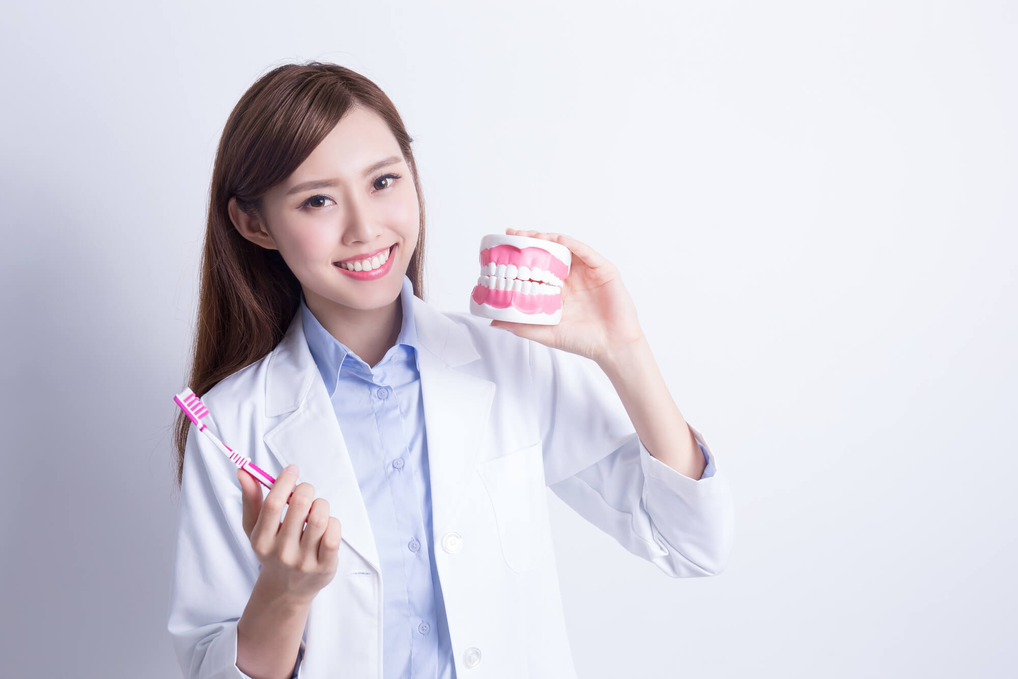 Dentist in Dania Beach holding a denture model