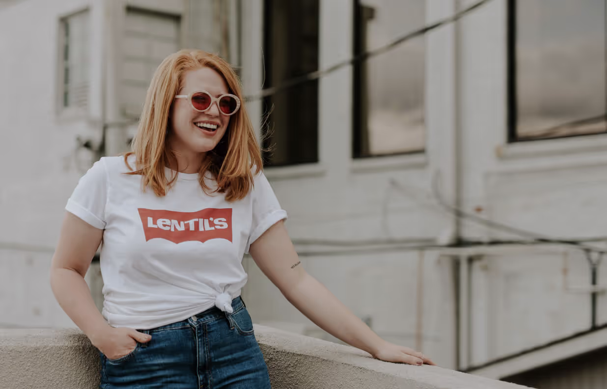 A woman wearing a white shirt with red letters.