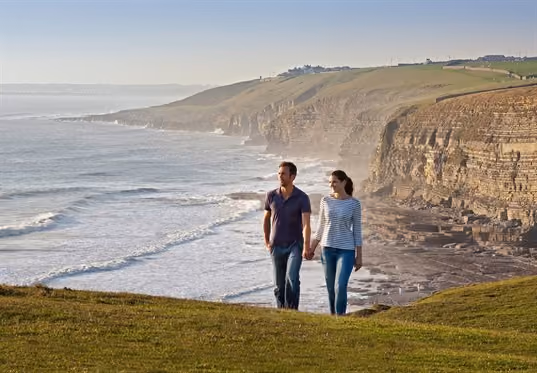 A couple of adults walking along the coast path