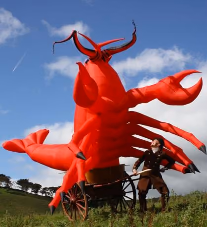 A giant inflatable lobster being pulled in a cart