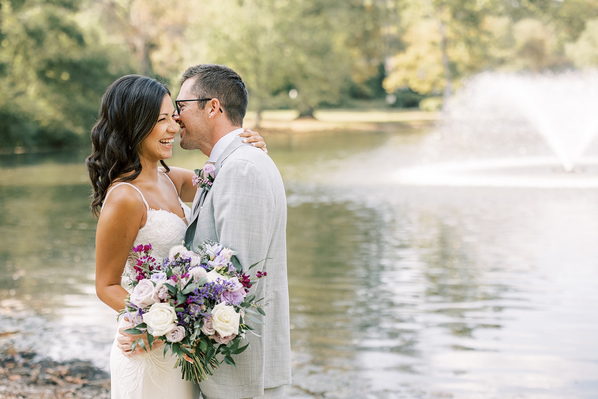 Bride and groom down the hillside in front of the pond at The Willows