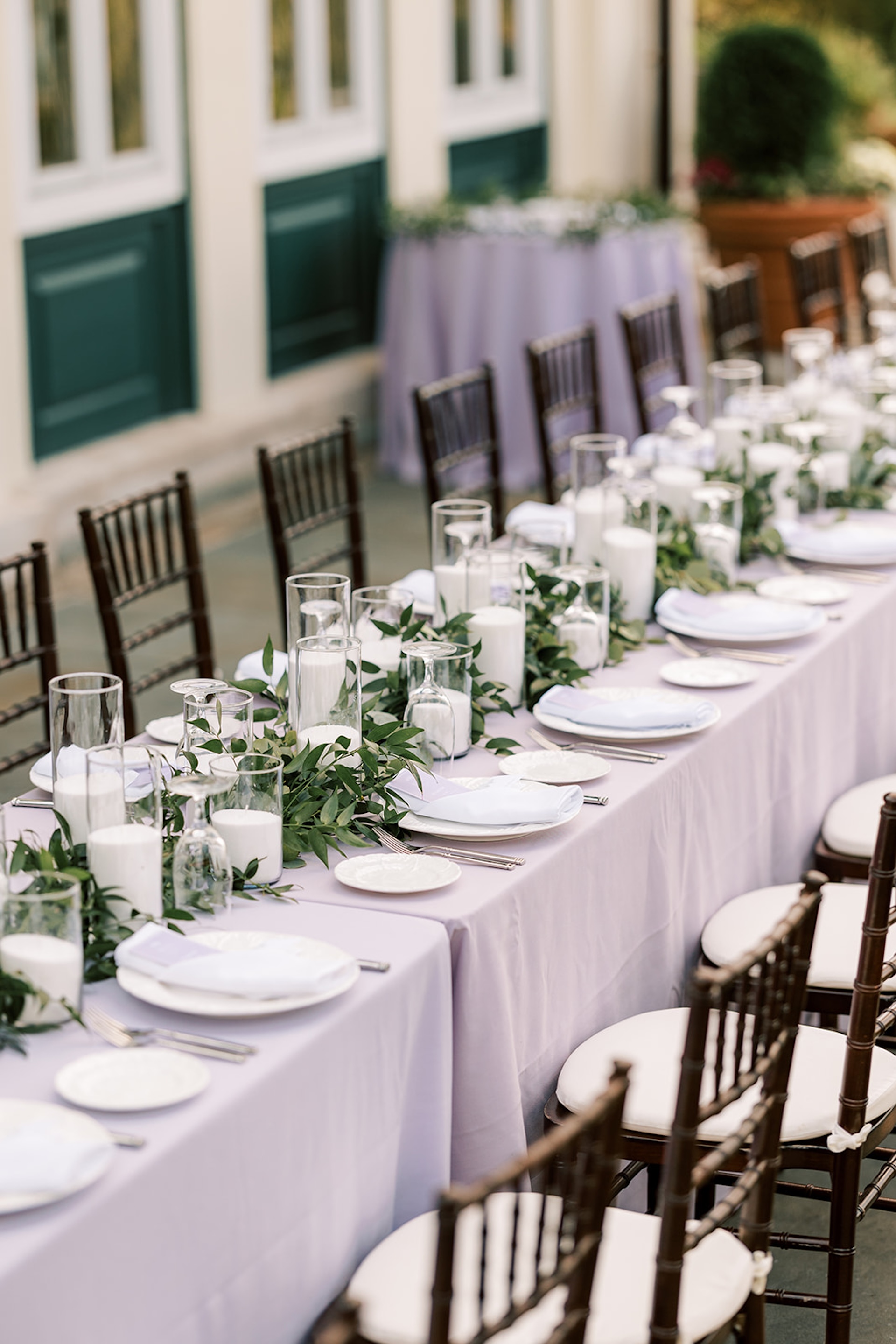 dining al fresco at long tables on the back patio of The Willows Mansion overlooking the grounds