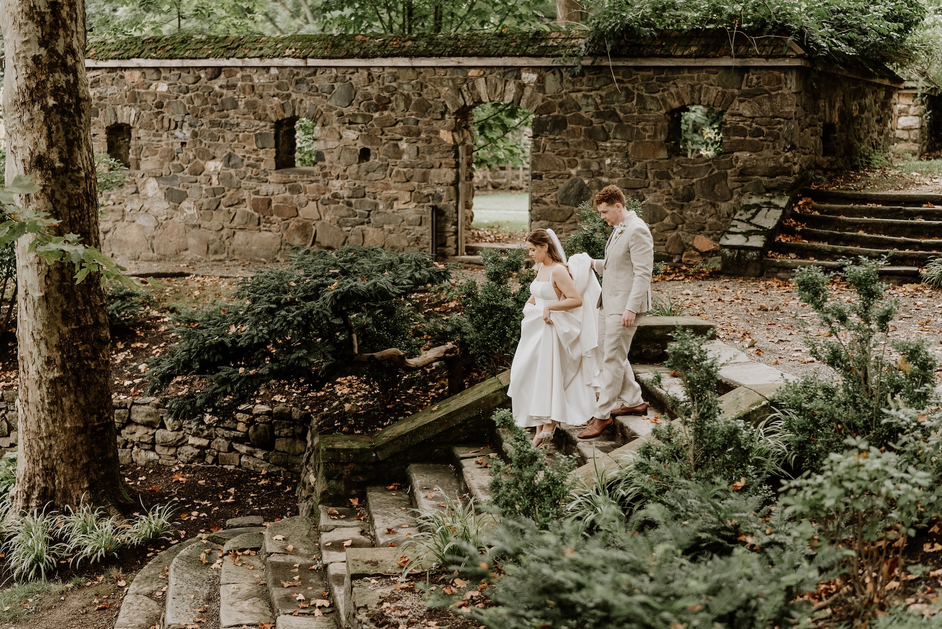 Bride and groom on stairs of Parque grounds w/ gorgeous stonework 