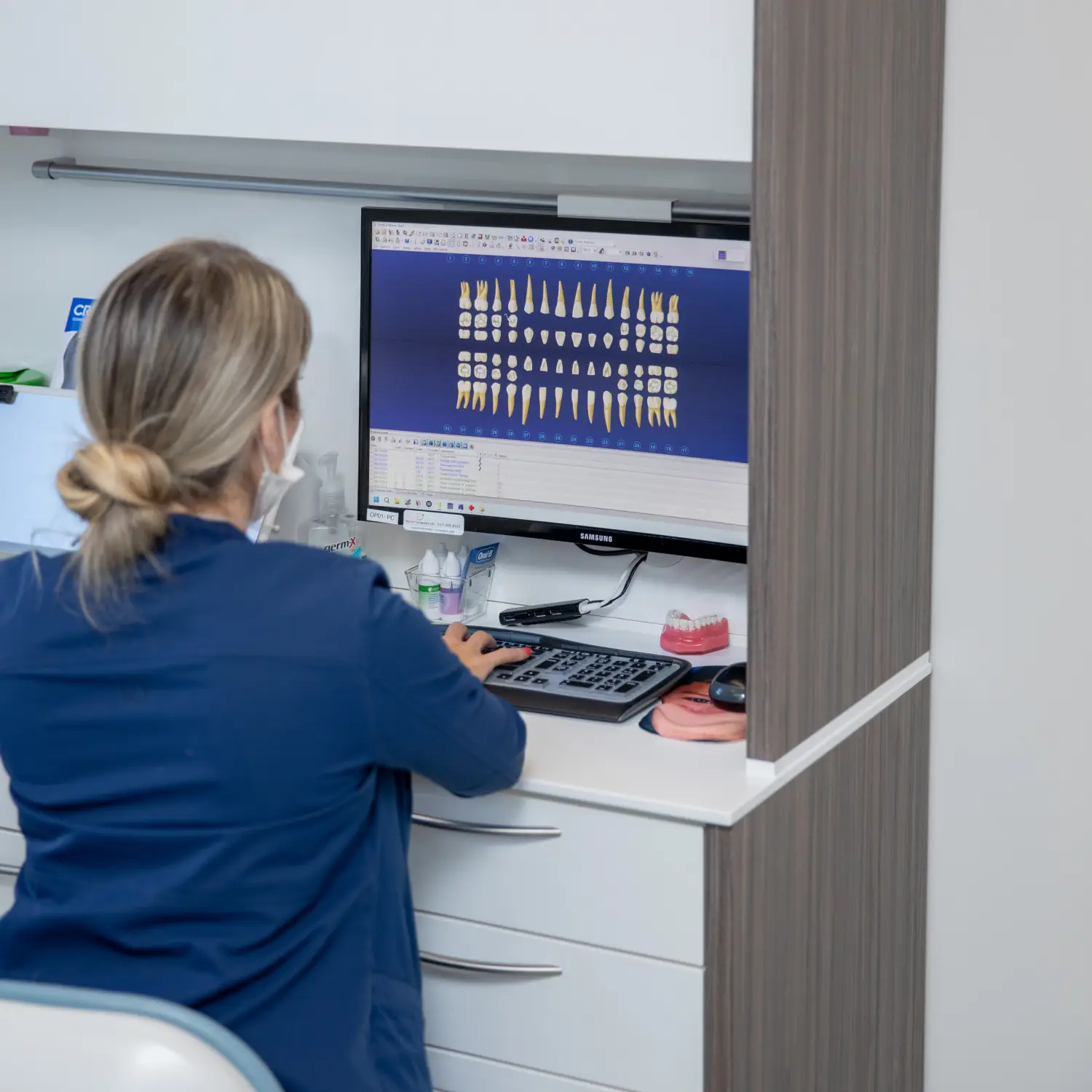 patient smiling and holding up invisalign 