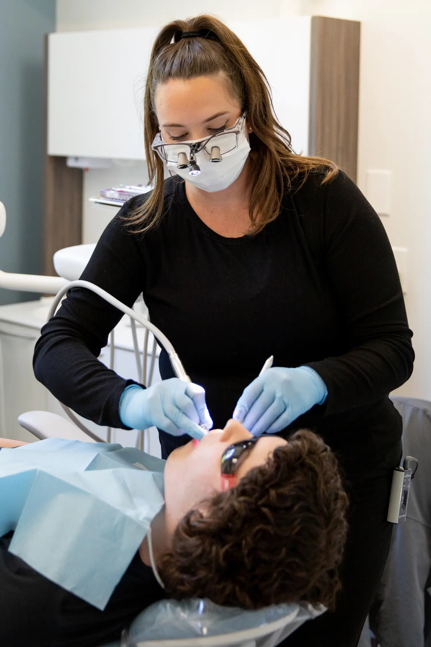 patient smiling and holding up invisalign