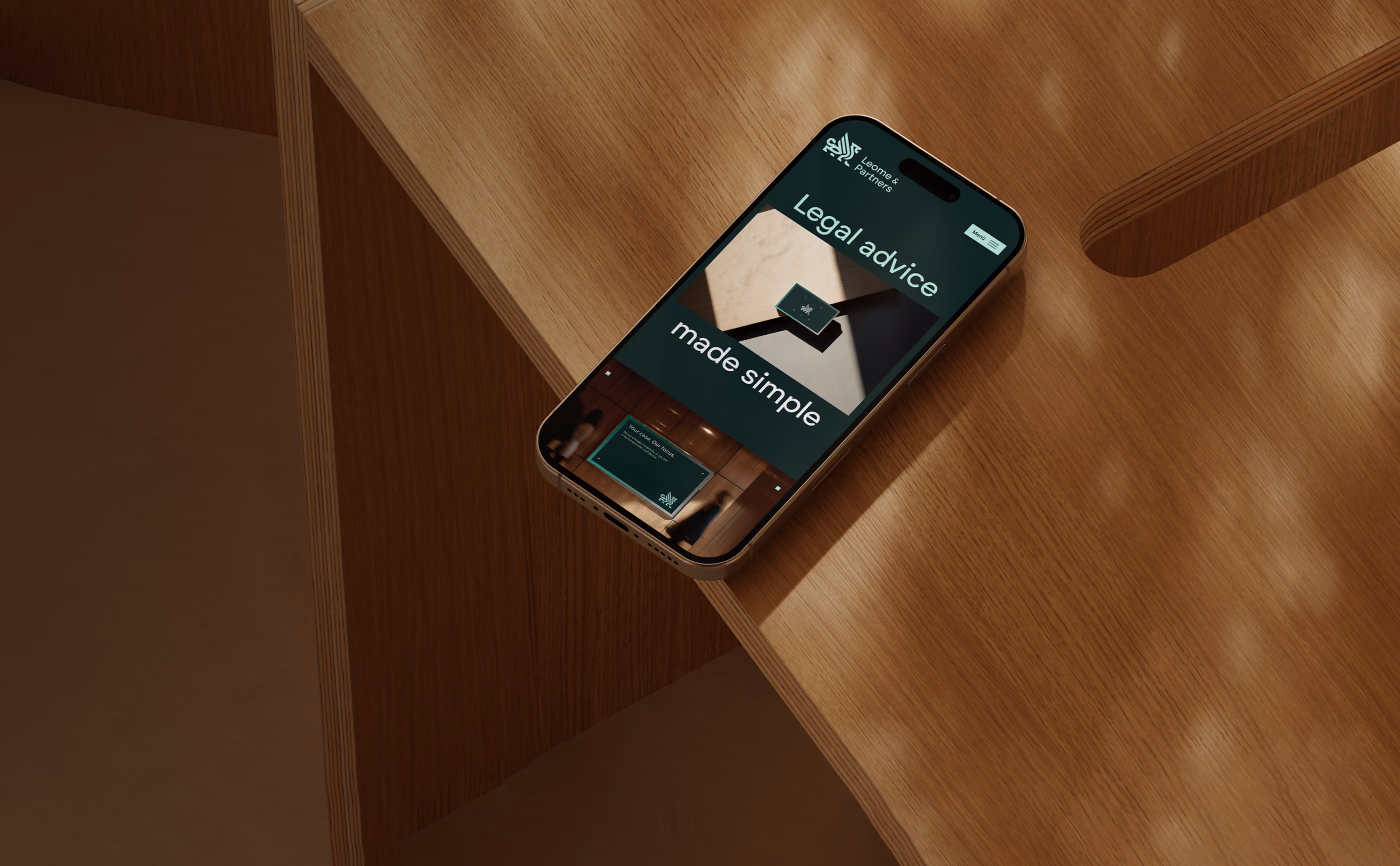 iPhone Mockup auf einem Holztisch zeigt ein grünes Webdesign von einer Anwaltskanzlei Leome & Partners.