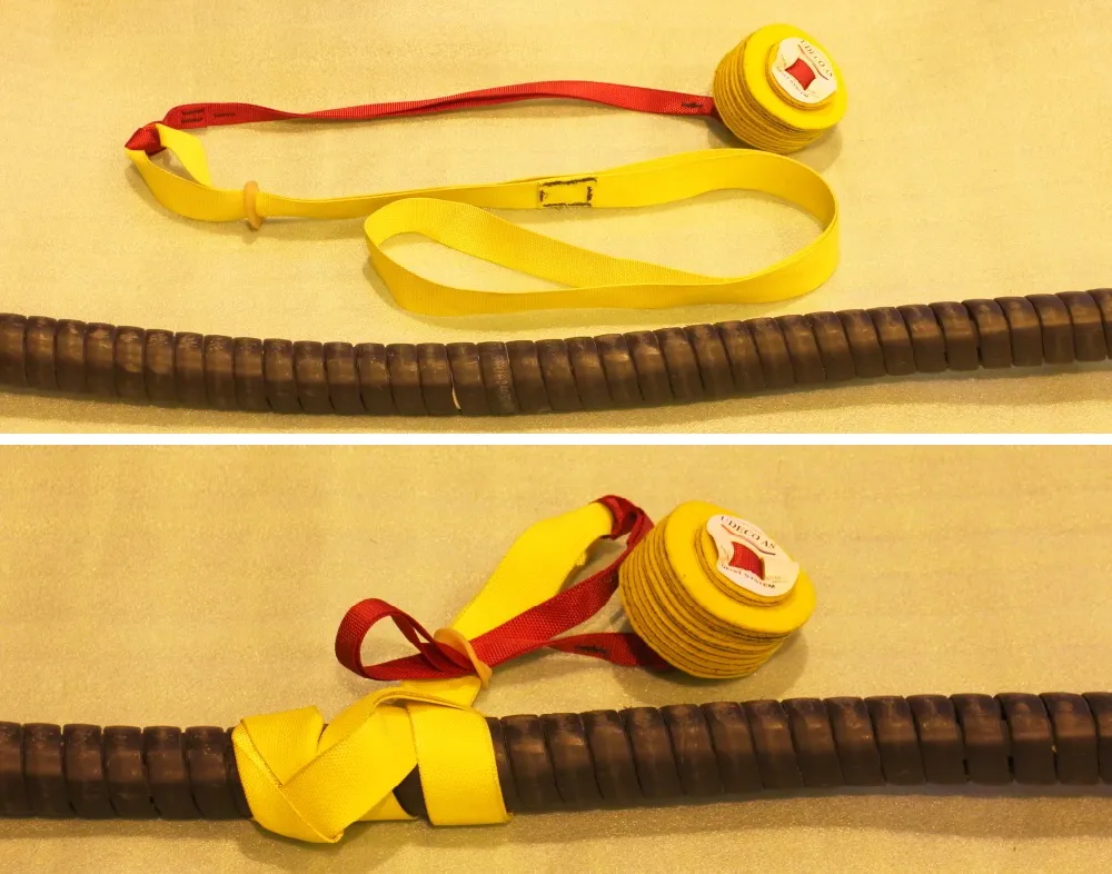 Large ball fist with anti-slip strap and yellow lifting straps for subsea flying lead installation, displayed on a textured surface.