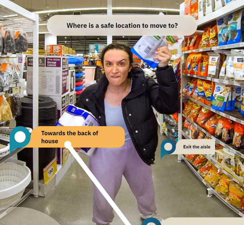 Retail de-escalation training scenario: an aggressive customer in a supermarket aisle, with a prompt asking where a safe location to move to is.