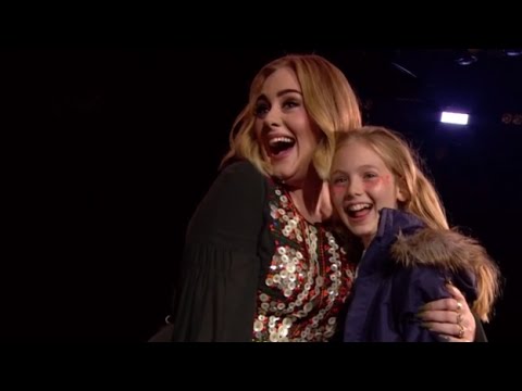 Adele poses with a young female fan.