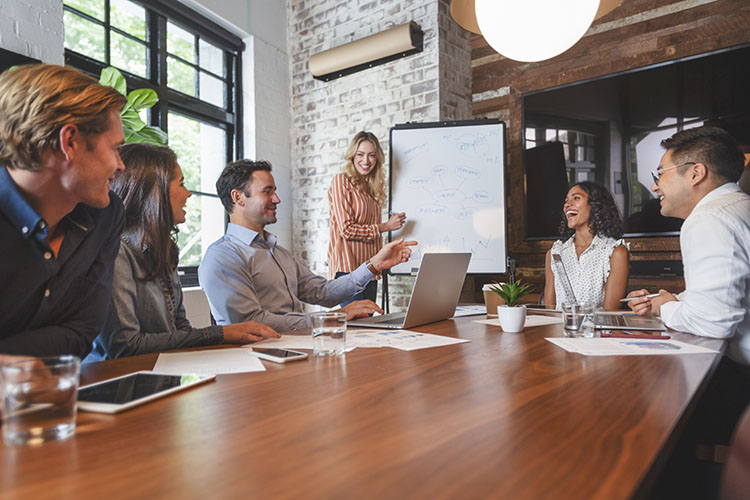 Content and social marketing strategist in a meeting discussing their audience and what patterns they have notices through Nuvi's Language Engine and social listening tools.
