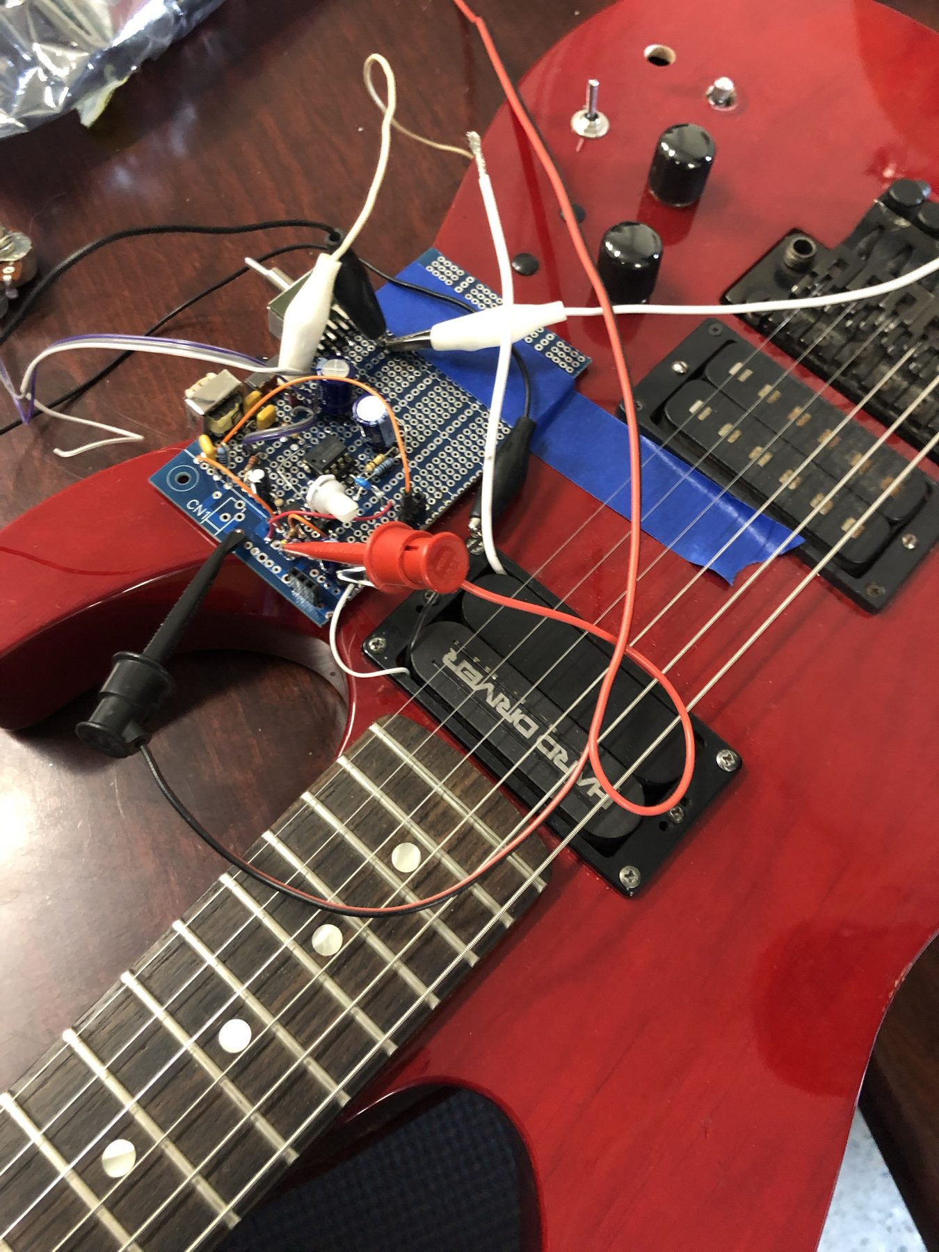 A Hard Driver sustainer unit and control board bench-tested in a red electric guitar