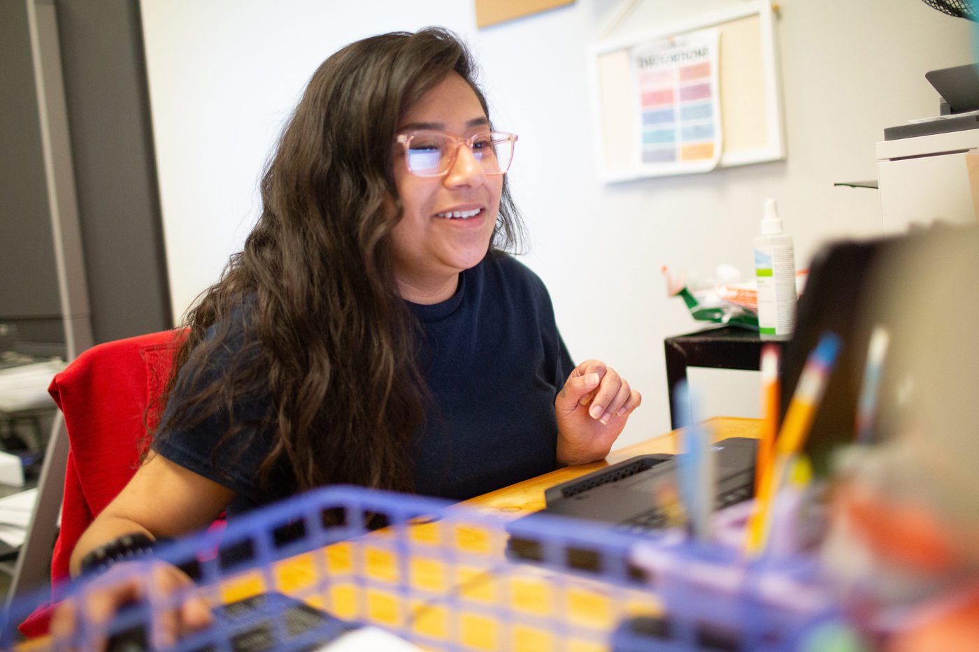 A woman works at a computer within a prison setting