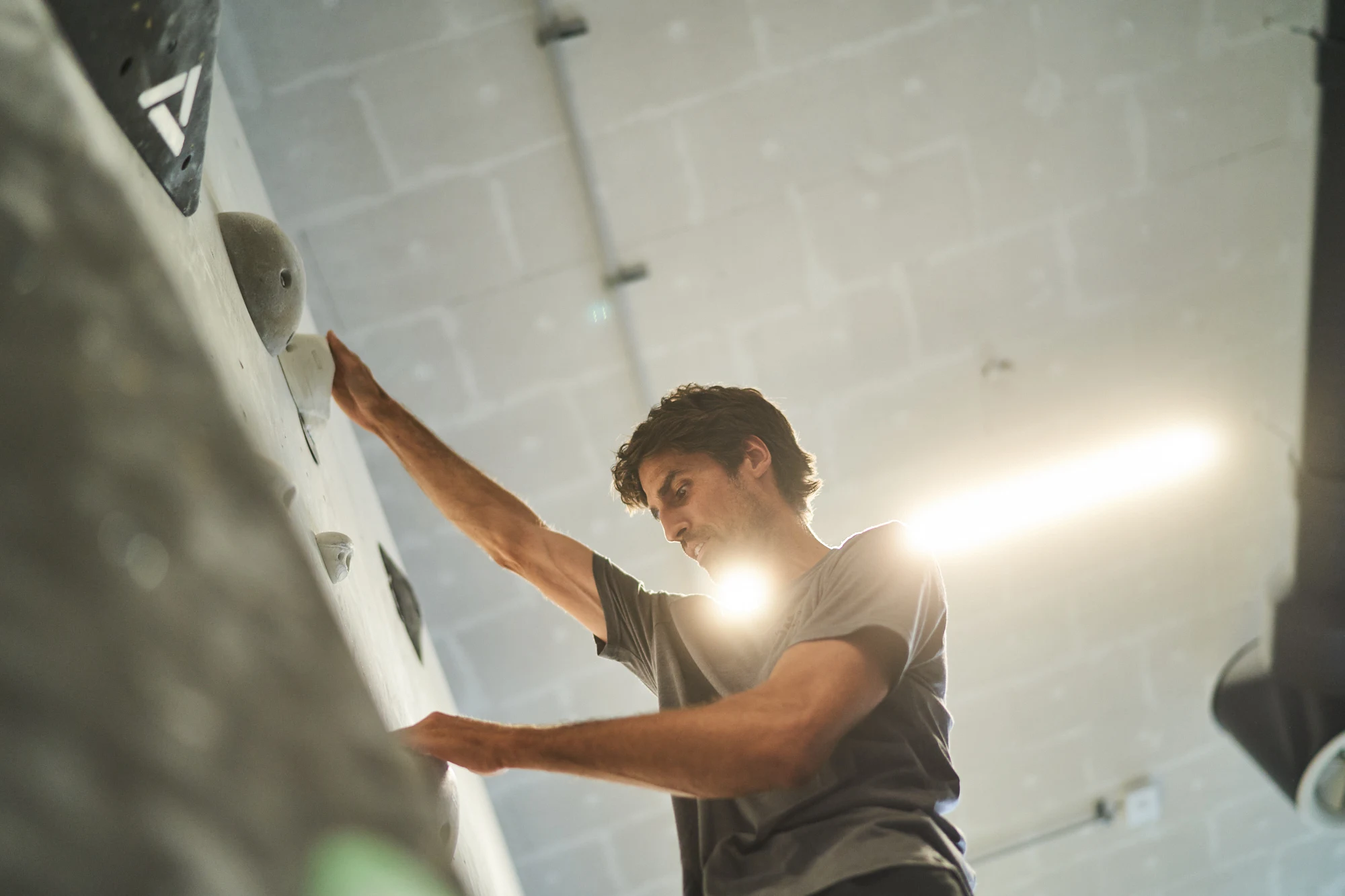 Mann klettert in Indoor Kletterhalle hinauf