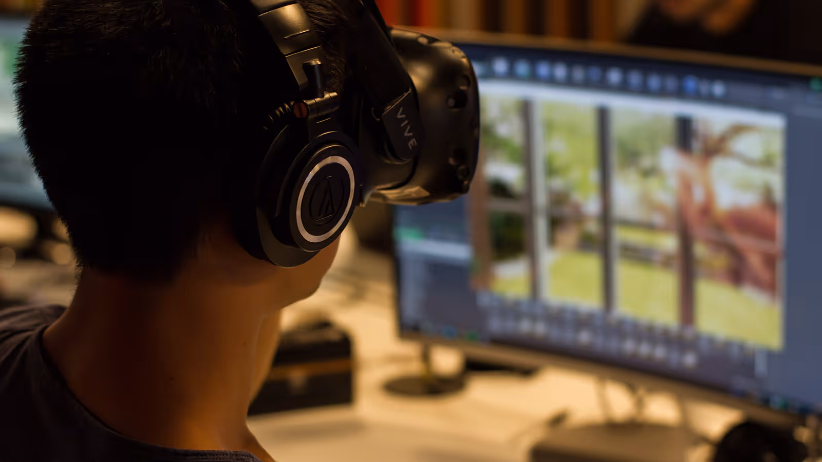 a person wearing headphones and looking at a computer screen