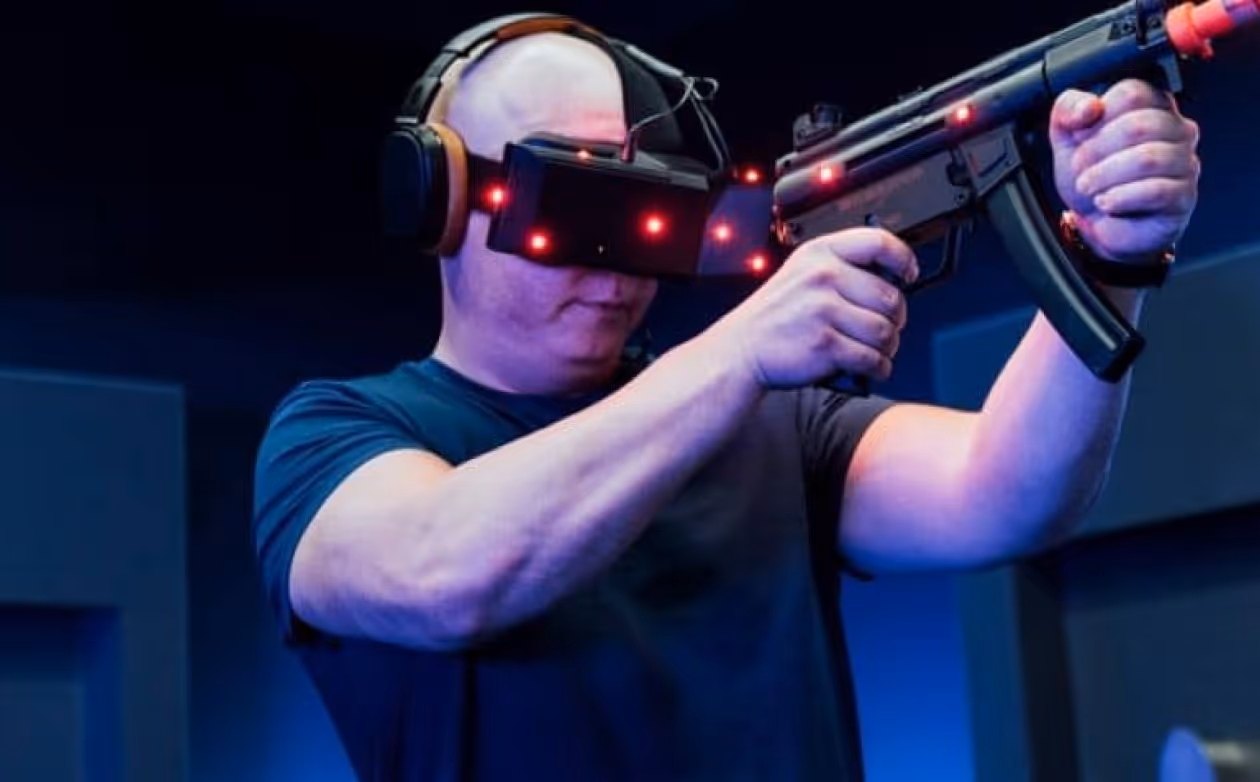 a man wearing virtual reality goggles and holding a gun