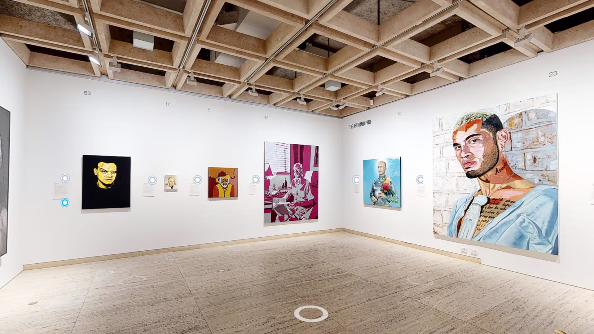 Matterport tour view of a gallery room hung with Archibald Prize portrait finalists, with navigation points on the floor.