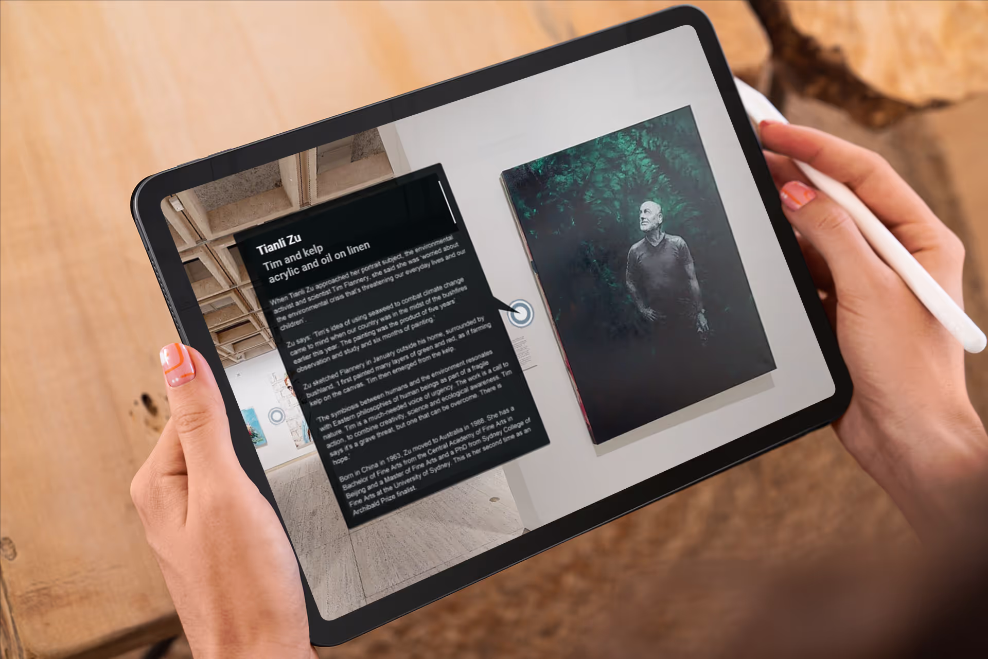 A person holds an iPad Pro displaying a Matterport tour info panel for Tianli Zu's portrait "Tim and kelp," alongside the painting on the gallery wall.
