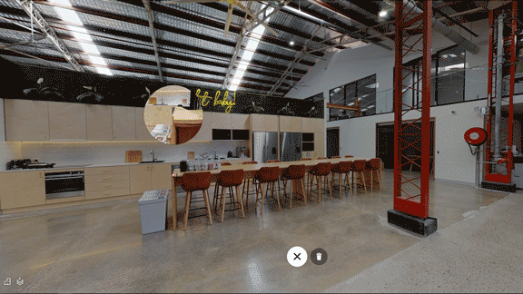 Animated Matterport tour of the Workit Spaces kitchen, showing a long communal table, bar stools, and a measurement annotation on the counter.