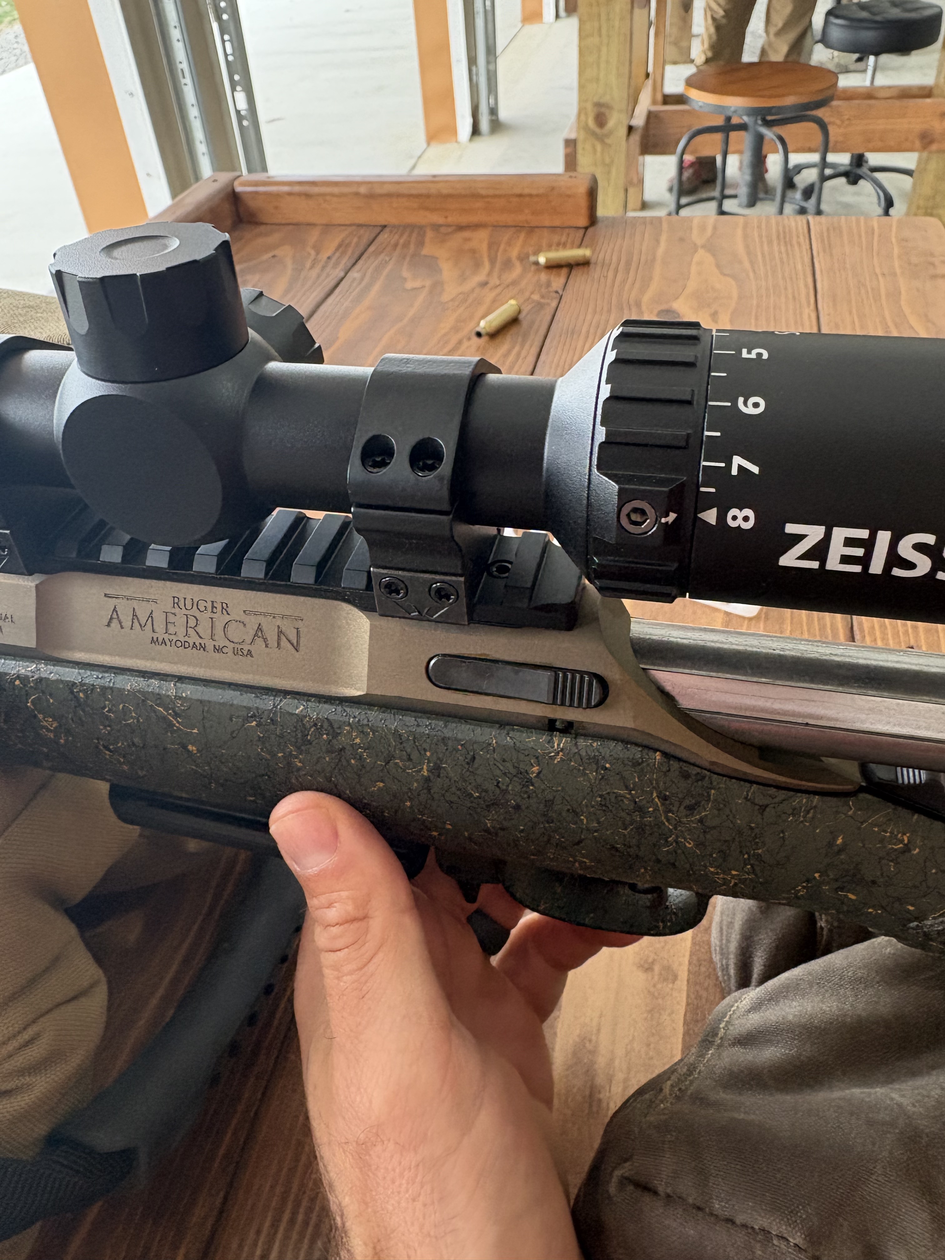 Close-up of the Zeiss V3 turret and elevation markings mounted on a Ruger American rifle at the shooting range