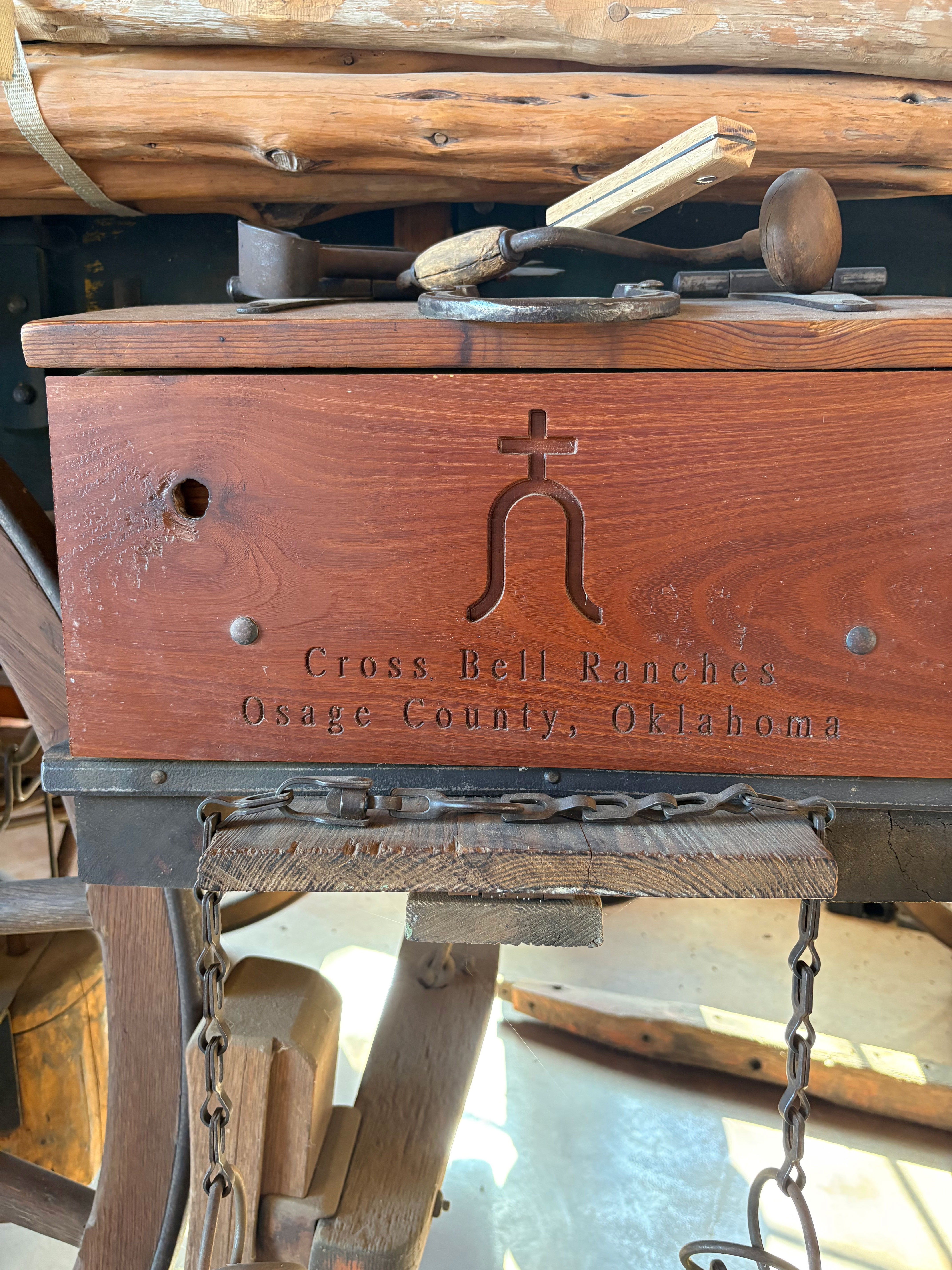 Carved wooden Cross Bell Ranches sign, Osage County, Oklahoma, on a historic ranch workbench