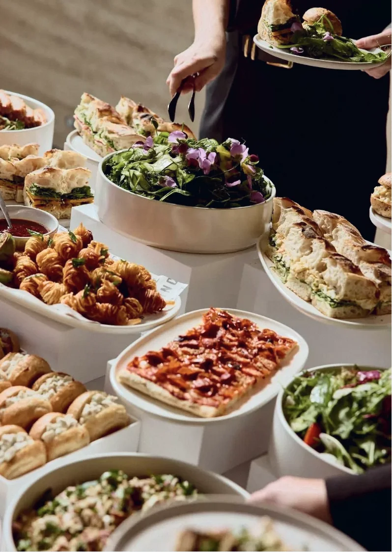 Catering buffet with focaccia sandwiches, pastries and salads