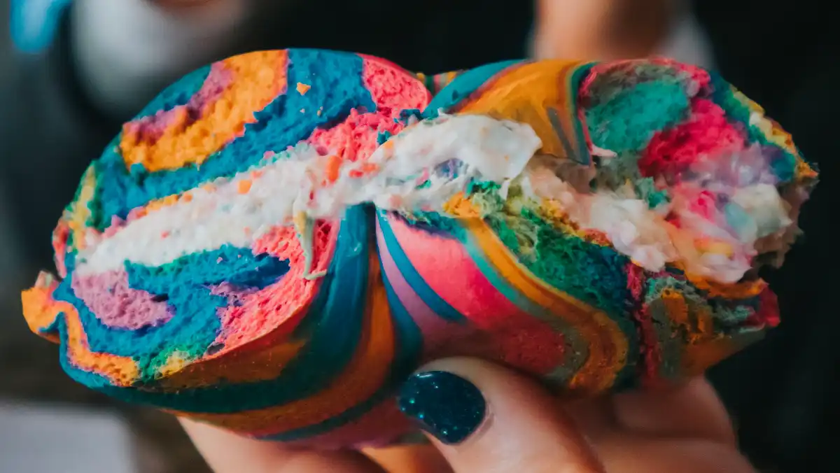 Rainbow bagel with cream cheese.